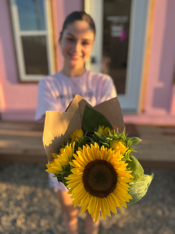 girl holding bouquet of sunflowers outside of Fort St. John BC