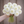 Bouquet of white Blizzard dahlia flowers held by a person against a wooden background