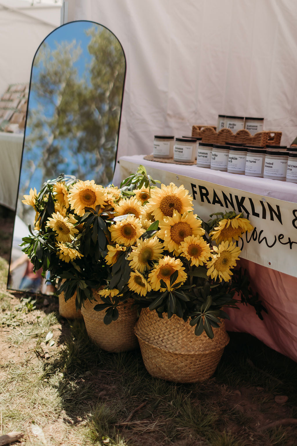 Potted sunflowers in baskets at the Franklin & Co. Flower Farm booth at Summer in Bloom