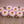 Pink and yellow Ferncliff Illusion dahlia flowers with green stems on a wooden surface