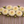 Arrangement of light yellow Innocent Silence Dahlia flowers with green stems on a pinkish-brown background