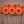 Arrangement of orange Nicholas dahlia flowers on a brown background