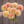 Bouquet of peach-colored Sweet Suzanne dahlias held by a person against a wooden background